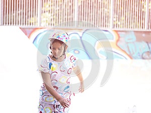 Little pretty girl on roller skates in helmet at a park