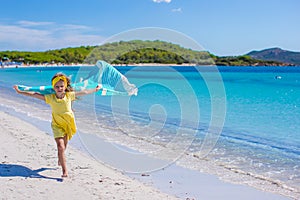 Little pretty girl running along the beach with