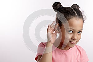 Little pretty girl is showing her ears to the doctor.