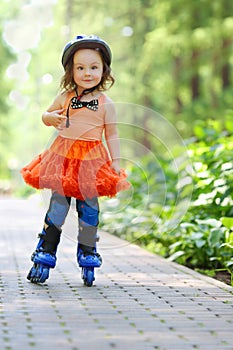 Little pretty girl in skirt and helmet roller