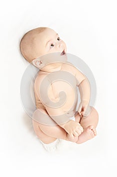 Little pretty kid. Lying at home. White background. Happy expression