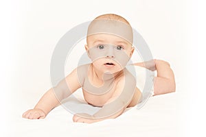 Little pretty kid. Lying at home. White background. Happy expression