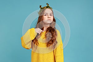 Little princess girl standing and pointing finger to herself, looking at camera with confidence.