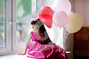 Pequeno princesa en rosa ropa posesión globos 