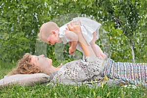 Little princess playing outdoor. Baby girl on mother`s hands. Smiling toddler with mother. Life beginning concept