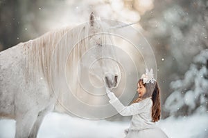 The little princess with an unicorn in the forest.