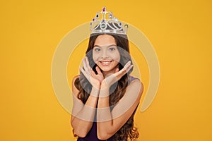 Little queen wearing golden crown. Teenage girl princess holding crown tiara. Prom party, childhood concept. Happy girl