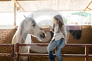Little Rancher Caressing Horse In Stable
