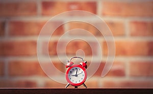 Little red alarm clock on table