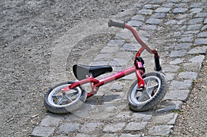 Little red bycicle on the ground