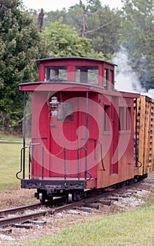 The little red caboose on train tracks