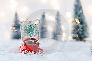 Little red car toy carrying Christmas tree