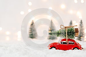 Little red car toy carrying Christmas tree