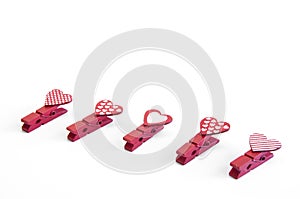 Little red clothespins hearts. On white background. Love