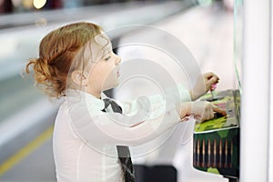 Little red hair girl in white shirt and tie plays