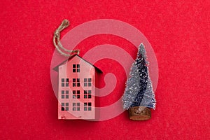 Little red house and little christmas tree on red background
