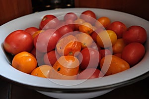 Little red tomatoes in a big iron bowl on a kitchen