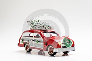 Little red vintage car carrying a Christmas tree on top