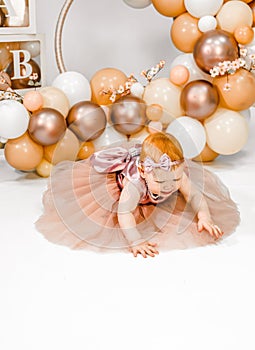 Little redhead baby girl celebrates first birthday anniversary. 1 year family baloons party. Professional photoshoot