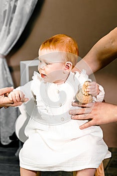 Little redhead baby girl celebrates first birthday anniversary. 1 year family party Professional photoshoot in photo
