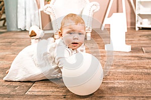 Little redhead baby girl wih balloon celebrates first birthday anniversary. 1 year family party Photoshoot in photo