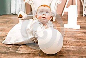 Little redhead baby girl wih balloon celebrates first birthday anniversary. 1 year family party Photoshoot in photo