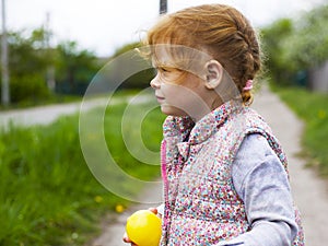 Little redhead girl with pigtails looks away