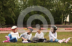 Little roller skaters sitting on grass