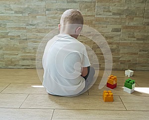 Little sad boy sitting on the floor unhappy a block depression frustratedsadness