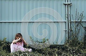 Little sad girl crying alone outdoor