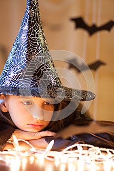 Little sad girl in witch costume, halloween