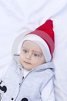 Little Santa. 1 year old baby boy in Santa Claus cap. Christmas kids
