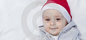 Little Santa. 1 year old baby boy in Santa Claus cap. Christmas kids