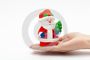 Little Santa Claus toy on the woman`s hand isolated on white background. christmas and new year concept