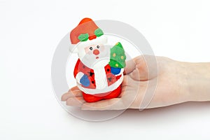 Little Santa Claus toy on the woman`s hand  on white background. christmas and new year concept