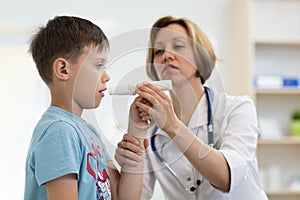 Little boy blowing to peak metr medical device. Doctor examining child`s lungs