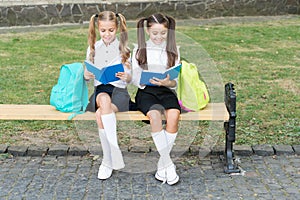 Little school friends girls with backpacks, reading books concept