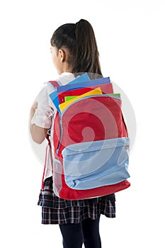 Little school girl carrying very heavy backpack or schoolbag full