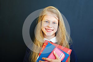 Little school girl near school blackboard