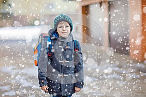 Little school kid boy of elementary class walking to school.