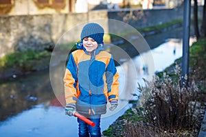 Little school kid boy of elementary class walking to school on cold winter day. Happy child in warm winter clothes