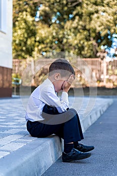 A little schoolboy is crying at school. doesn`t want to go to first class