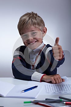 Little schoolboy showing thumb up