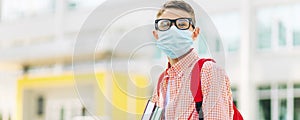 Little schoolboy wearing a mask during an outbreak of corona and flu virus, Little boy breathing through a mask while going to