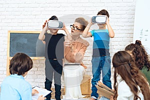 Little schoolchildren get acquainted with technology of virtual reality.