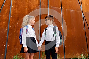 Little schoolchildren look at each other.