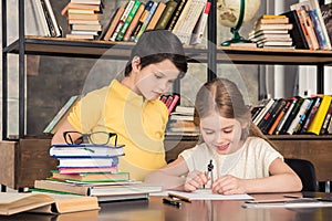 Little schoolchildren studying in library together