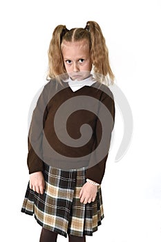 Little schoolgirl girl with beautiful blonde hair in school uniform looking shy and timid