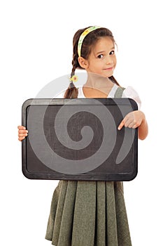 Little schoolgirl pointing to empty chalkboard