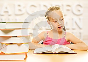 Little schoolgirl reading a book.